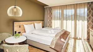 Ein Schlafzimmer mit einem Bett, einem runden Tisch mit Stühlen und einer Pendelleuchte.