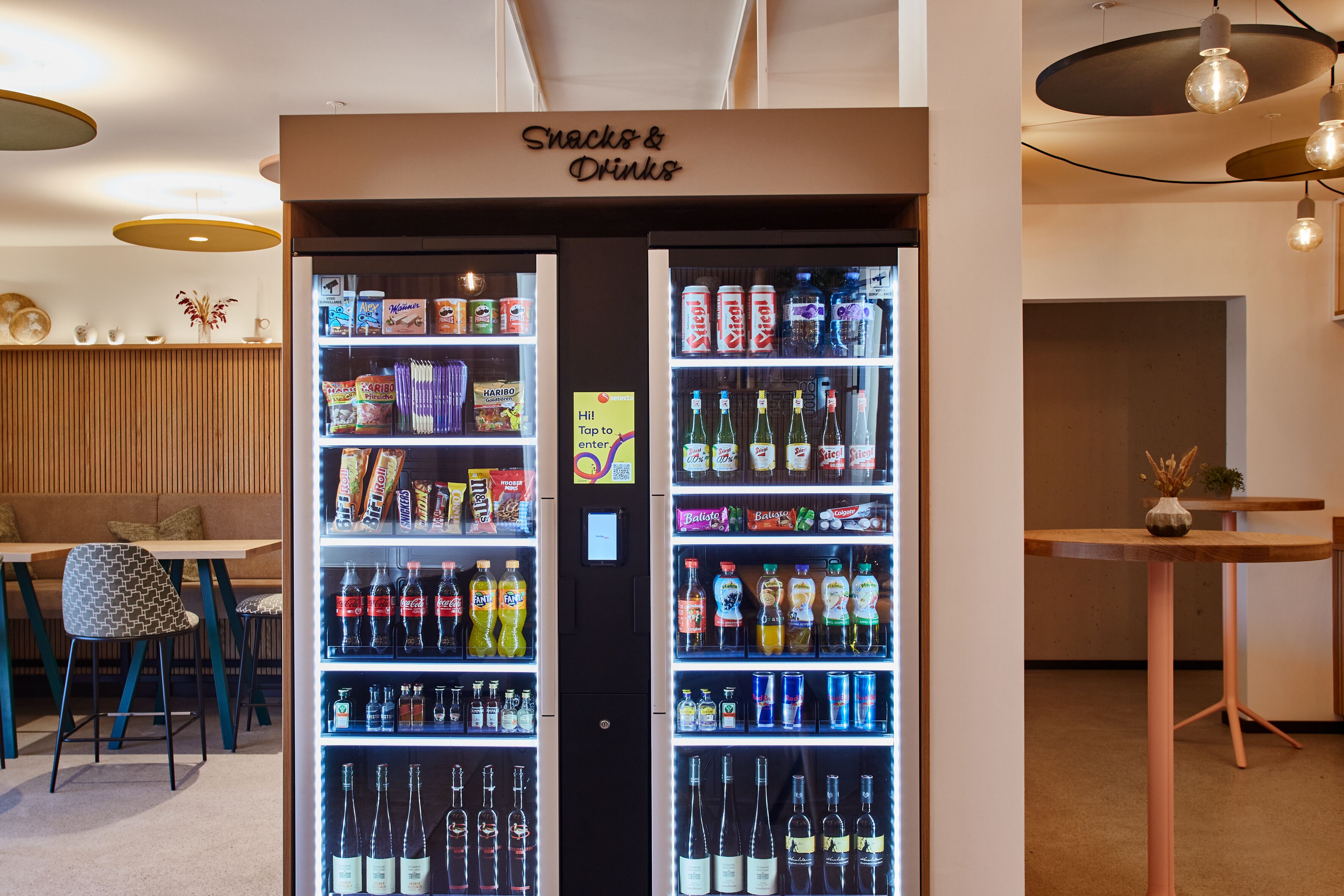 A vending machine labeled "Snacks & Drinks" with various snacks and beverages.