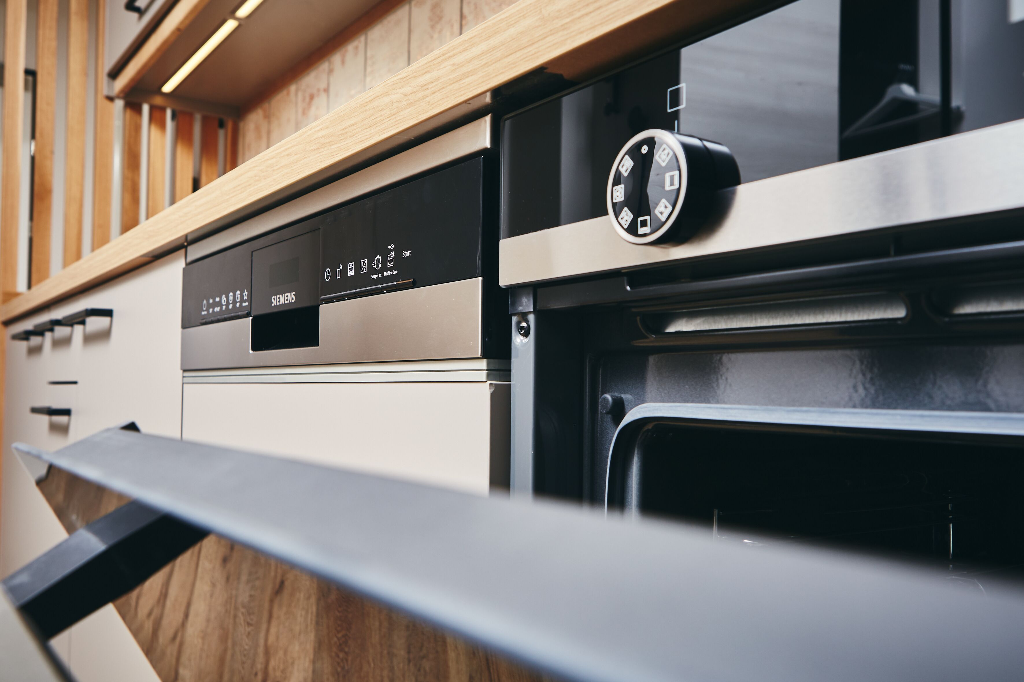Una cocina con horno de acero inoxidable y panel de control con pantalla digital.