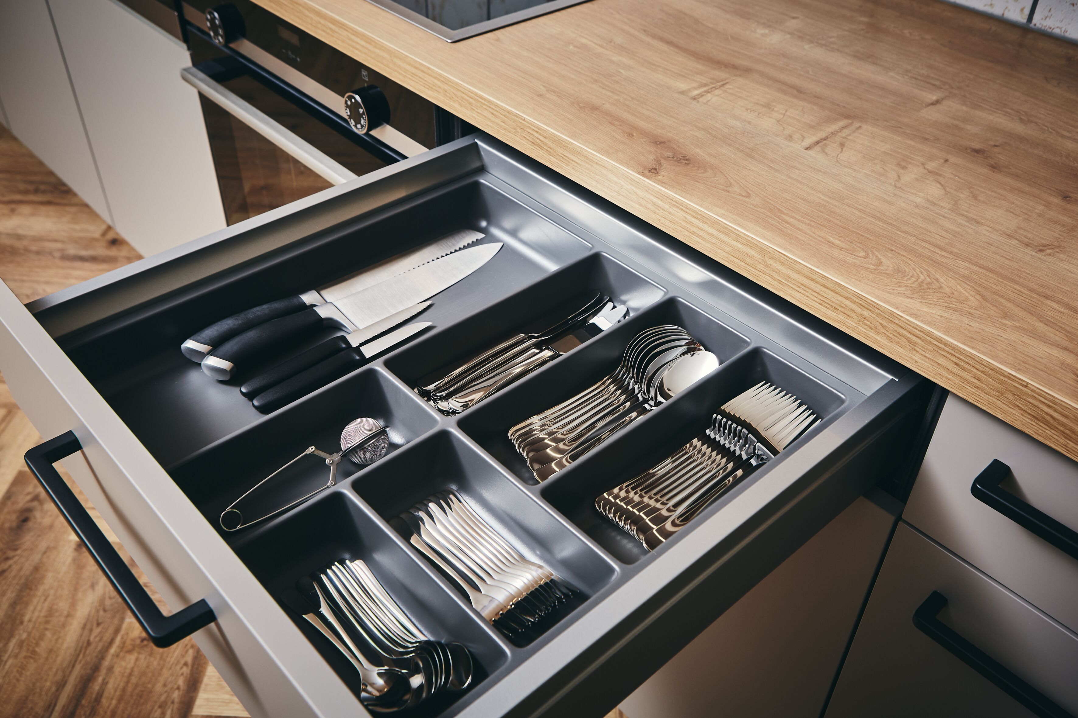 Un cajón de cocina con utensilios y utensilios de cocina.