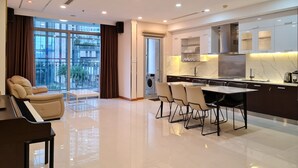 A modern kitchen with a dining area, large windows, and a piano.