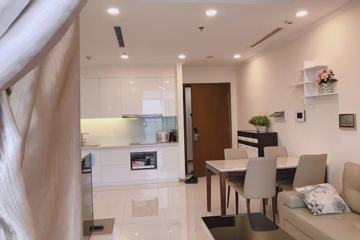 Um apartamento moderno com área de refeições, cozinha e sala de estar.