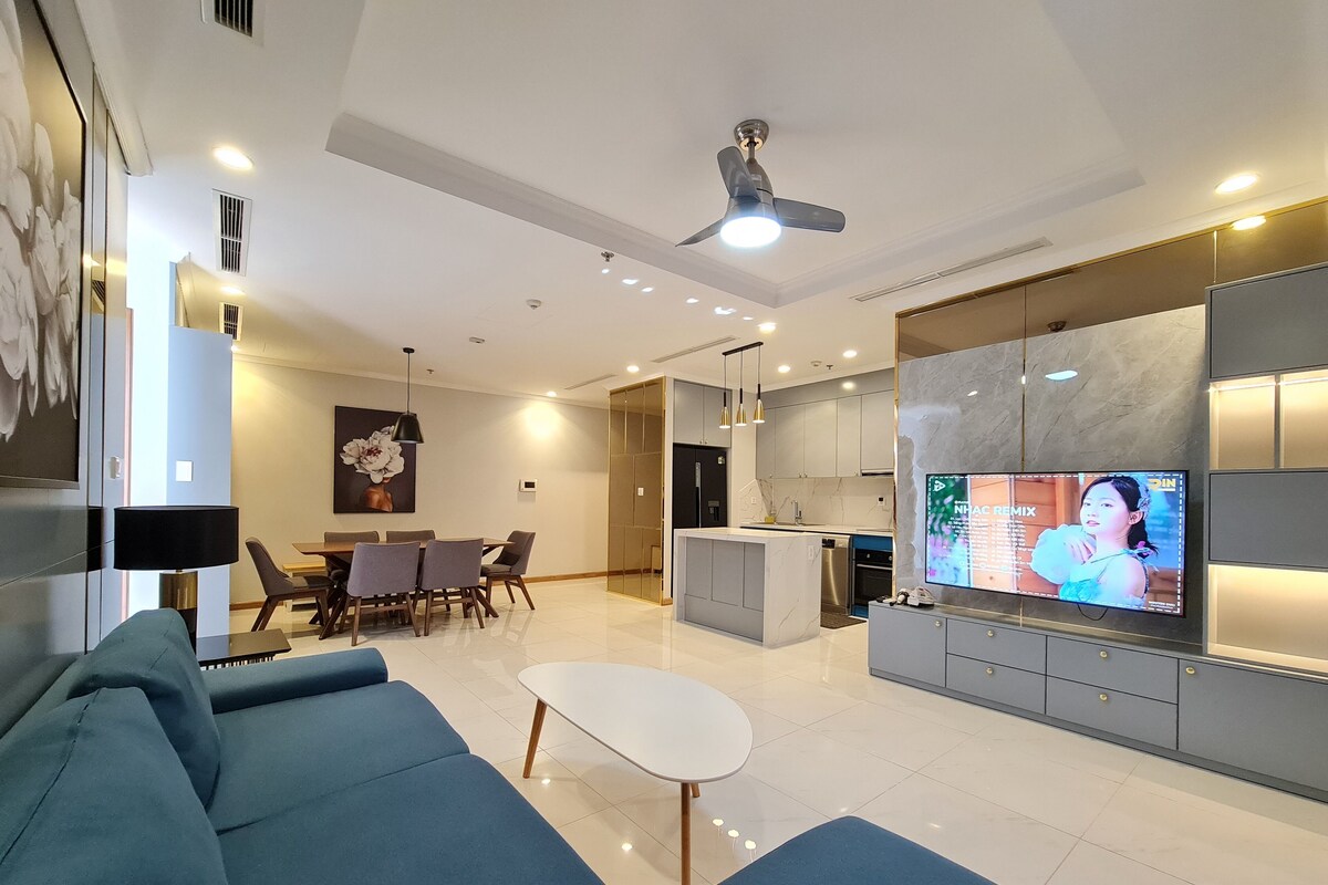Uma sala de estar moderna com sofá, mesa de jantar e televisão.