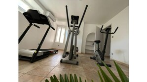 Ett hemmagym med löpband, crosstrainer och motionscykel.