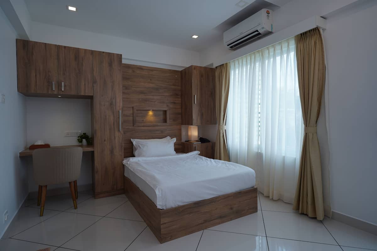 A modern bedroom with a wooden bed frame, a desk, and a chair.
