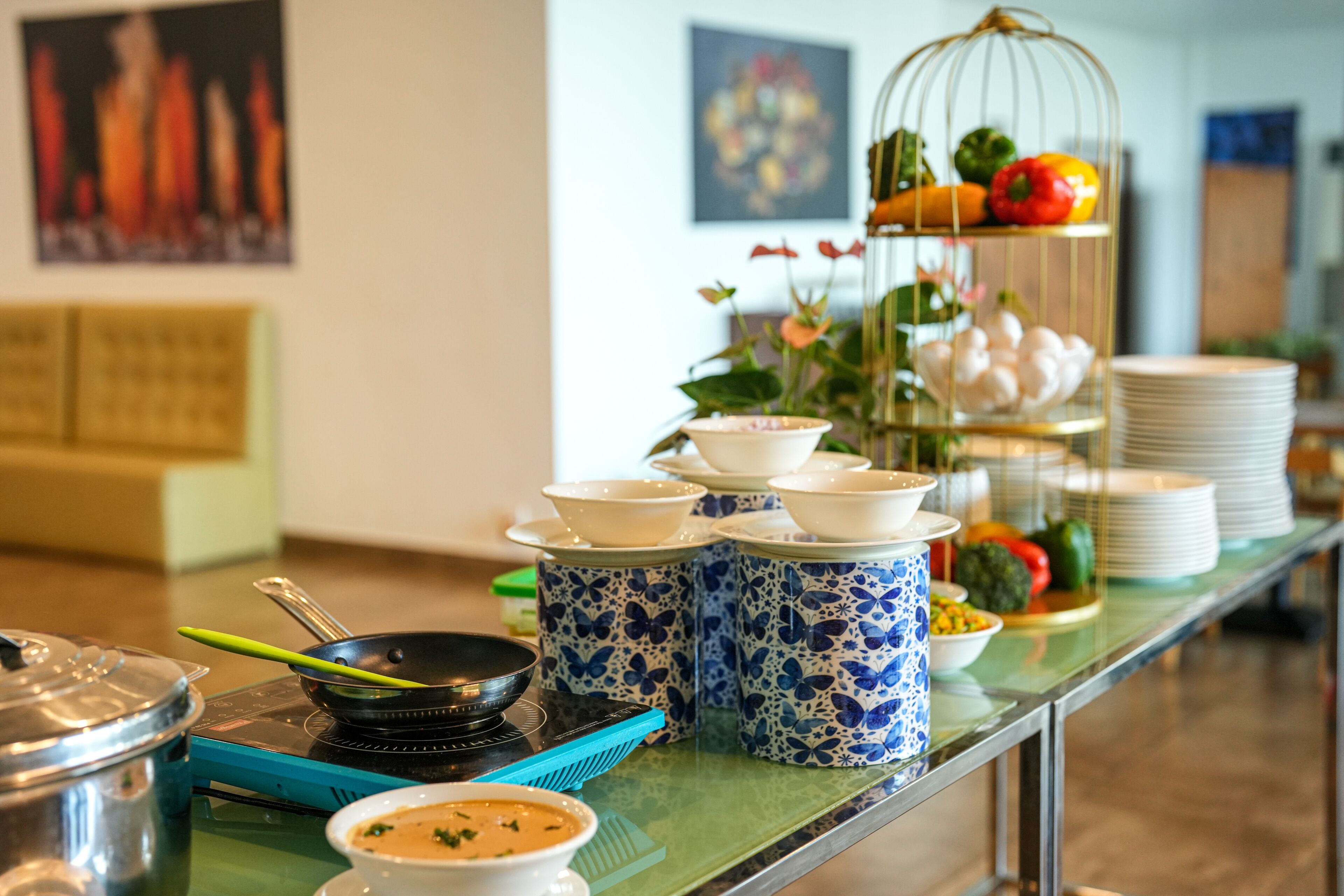 Una mesa con una variedad de platos en estilo bufé, una jaula decorativa y mantel verde.