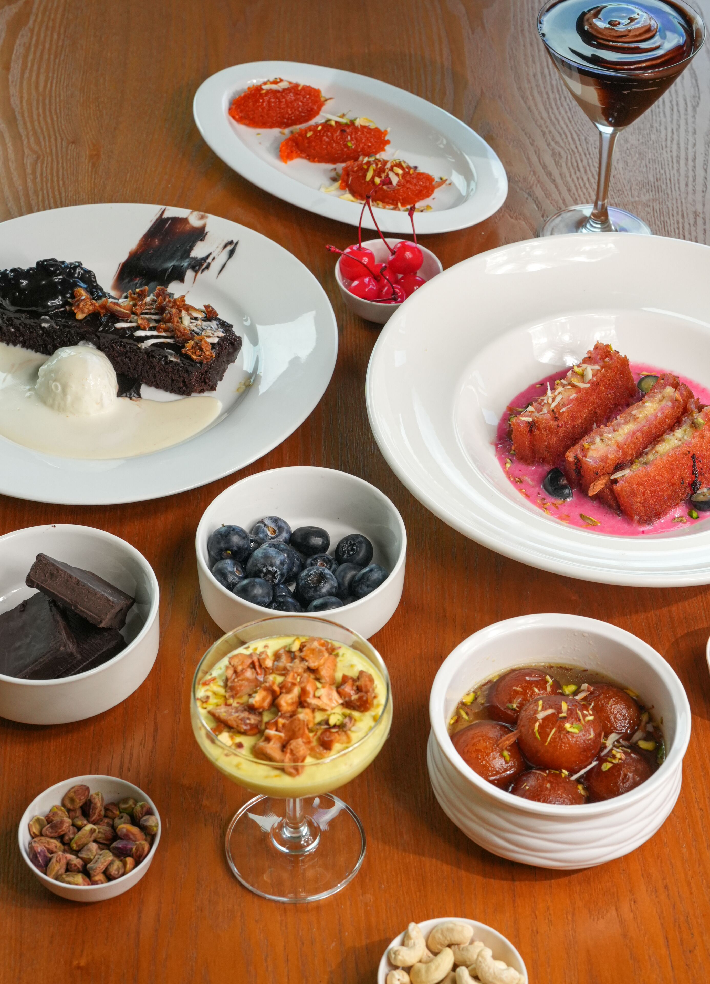 A variety of desserts and beverages on a wooden table.