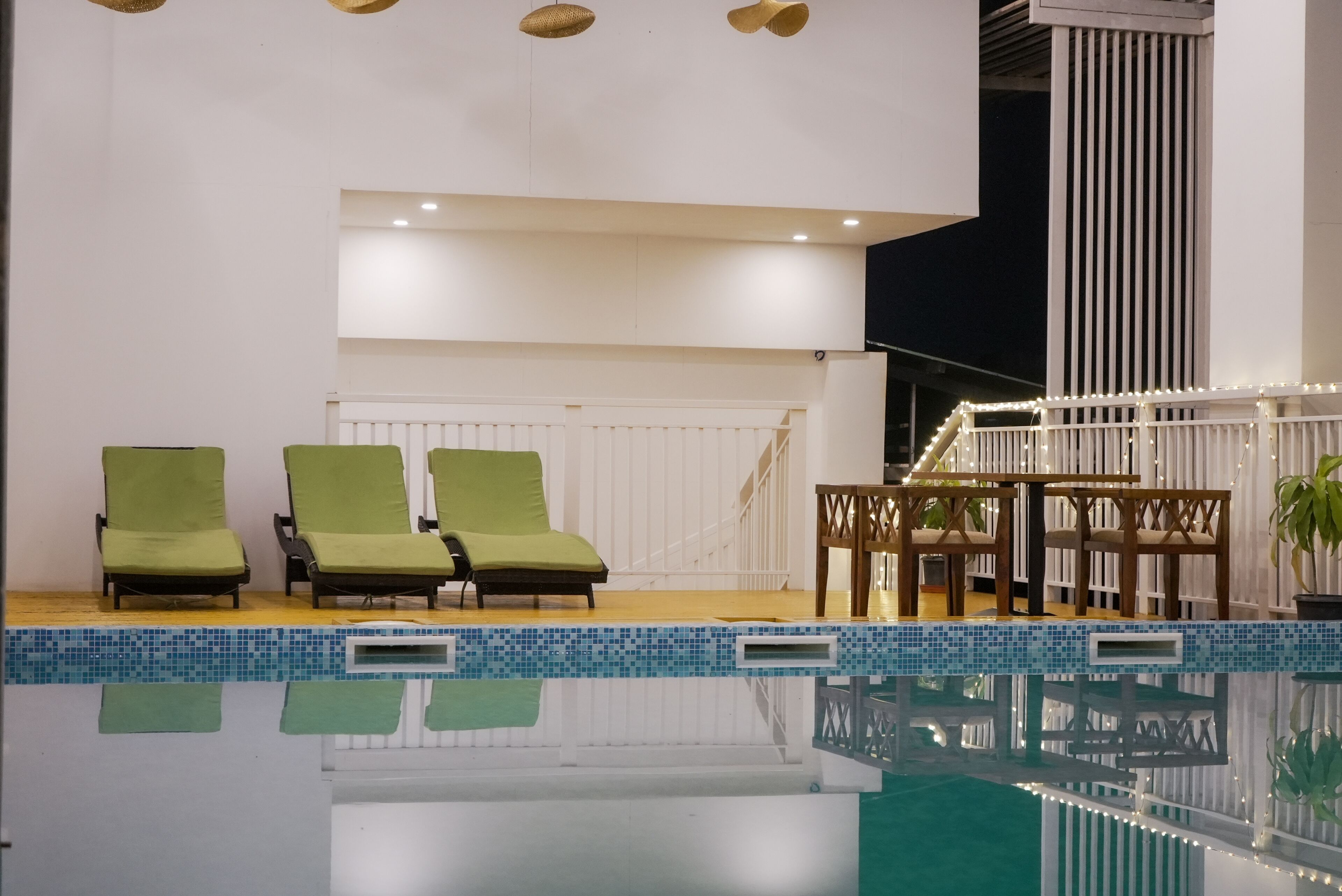 A swimming pool with lounge chairs and a wooden deck.