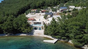 A coastal property with multiple buildings, a swimming pool, and solar panels. - Beachfront Villa Brulupes (Ston)