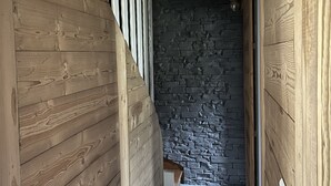 A wooden staircase with a stone wall in the background.