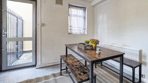 Une pièce avec une table en bois, un banc et une fenêtre ornée de rideaux légers.