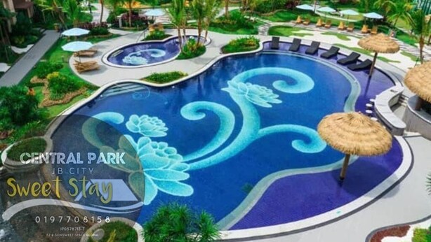 Ein Pool mit floralem Dekor, umgeben von Liegestühlen und Sonnenschirmen, was auf eine luxuriöse Urlaubsatmosphäre hindeutet.