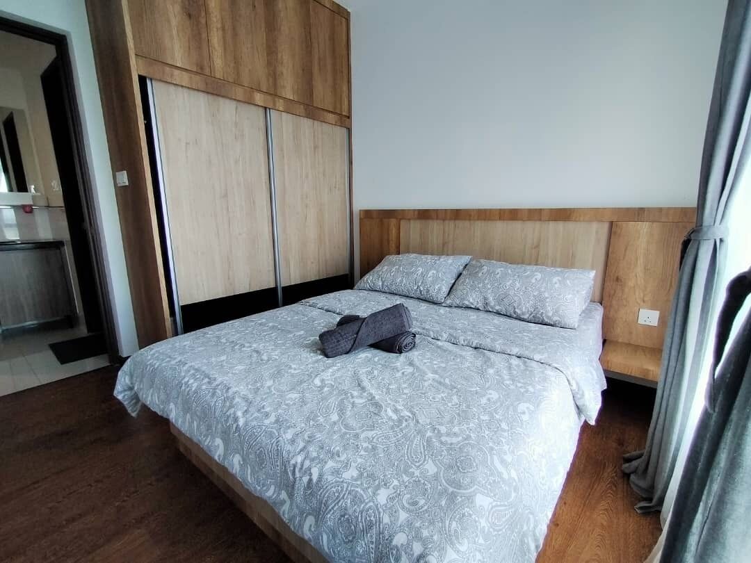 Ein Schlafzimmer mit Bett, Holz-Kopfteil und Kleiderschrank.