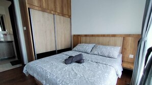 Un dormitorio con cama, cabecera de madera y armario.