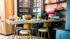 Una cocina con encimera de madera, sillas amarillas y diversos utensilios de cocina.