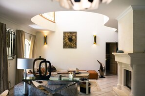 Uma sala de estar moderna com uma mesa de centro de vidro, um sofá e uma lareira.