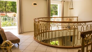 Un balcón amplio con barandilla metálica curva, un banco acolchado y un globo decorativo.