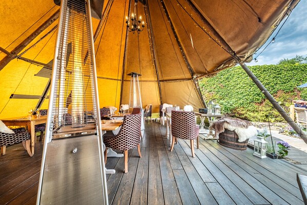 Relax in a cozy tent-style accommodation with a spacious deck and comfortable seating area.