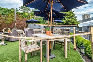 Relax in a secluded patio surrounded by lush greenery and traditional architecture.