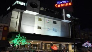 A hotel named 'Hotel Shaans' with a modern architectural design, featuring a prominent sign and a well-lit entrance. - Hotel Shaans (Tiruchirappalli)