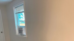 A small kitchen with a refrigerator, a window with blinds, and a door. - Private, Clean and Charming at amazing rate (Manchester)