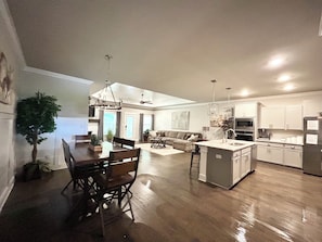 A spacious kitchen with a dining area, a living room, and a ceiling fan. - Spacious One Level Ranch Style Luxury Townhouse (Huntsville)