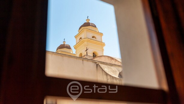 Blick durch ein Fenster auf ein Gebäude mit Kuppel und Glockenturm.