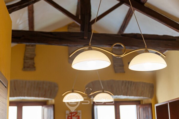 A ceiling with exposed wooden beams and three pendant lights.