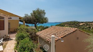 A villa with a tiled roof overlooking a coastal area. - Porto luna 24 - Selene (Villasimius)