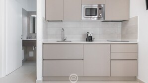 A modern kitchen with a built-in microwave, a coffee machine, and a sink. - Al Parco Studios - Studio Botticelli (Cagliari)