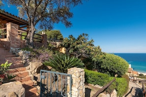 A coastal property with a stone staircase, a metal gate, and a view of the sea. - Casa Belvedere: Paradise in Costa Rei (Muravera)