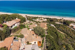 An aerial view of a coastal residential area with houses, a beach, and a clear blue sea. - Casa Belvedere: Paradise in Costa Rei (Muravera)