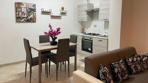 A modern kitchen with white cabinets, a gas stove, and a built-in oven.