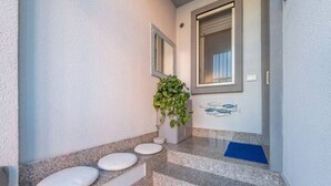 Un escalier avec des marches blanches et un tapis bleu au bas.