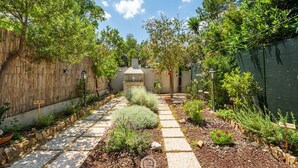 A garden pathway leading to a house with a chimney, surrounded by various plants and a wooden fence. - Grace's House: Your Oasis of Peace in Villasimius (Villasimius)