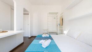 A hotel room with a bed, a desk, and a wardrobe.
