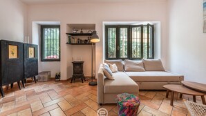 A living room with a sofa, a small table, a lamp, a bookshelf, and a fireplace. - Casa Flamingo - Next to the sea (Santa Margherita di Pula)