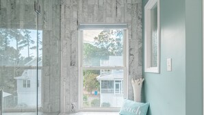 A room with a large window, a bench, and a cushion with the word "peace" on it. - Luxury Beach House, Private Pool & Jacuzzi, Ocean Views by Tybee Cottages (Tybee Island)