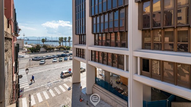 A modern building with large windows and a view of the street below.