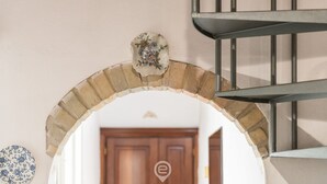 A staircase with a metal railing, a decorative wall piece, and a wooden door at the bottom.