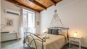 A bedroom with a bed, bedside table, and a desk.
