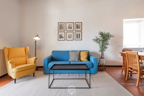 A living room with a blue sofa, yellow armchair, and a black coffee table.