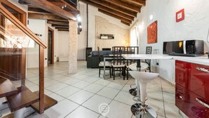 A spacious kitchen with modern appliances, a dining area with a white table and chairs, and a staircase leading to another level. - Maty's House (Gonnesa)