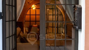 A cozy room with a bed, a hanging light fixture, and a view of a garden through a window.