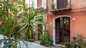 A courtyard with potted plants and a building entrance.