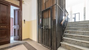 Una escala de marbre que mena a un ascensor.