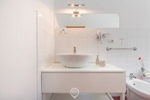 Tina con regadera, secadora de cabello, bidet, toallas 