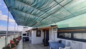 A balcony with a blue checkered table, potted plants, and a white chair. - Rooftop authentic close to metro (ÜMRANIYE)