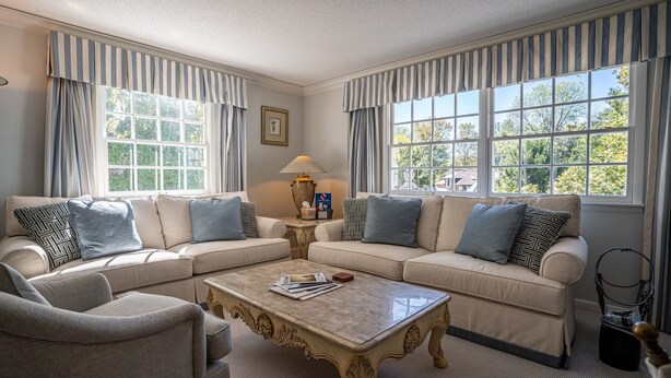 A living room with two beige sofas, a marble coffee table, and striped curtains. - Located in the Luxurious Pine Manor Estates! (Carbondale)