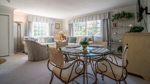 A dining area with a glass table surrounded by wicker chairs, a sofa, and a lamp. - Located in the Luxurious Pine Manor Estates! (Carbondale)